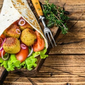 Vegetarian Tortilla wrap with falafel and fresh salad, vegan tacos. wooden background.